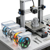A set of clear airtight filament storage boxes for PLA, PETG, TPU, and PA materials mounted on a 3D printer frame.