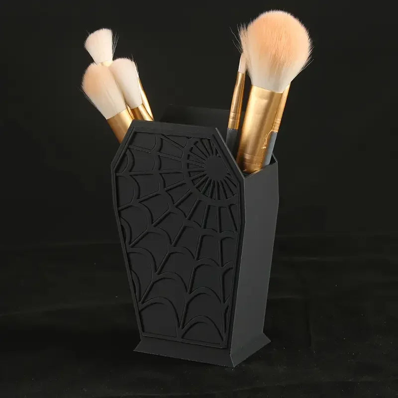 Black coffin-shaped makeup brush holder with a spider web design and gold handles