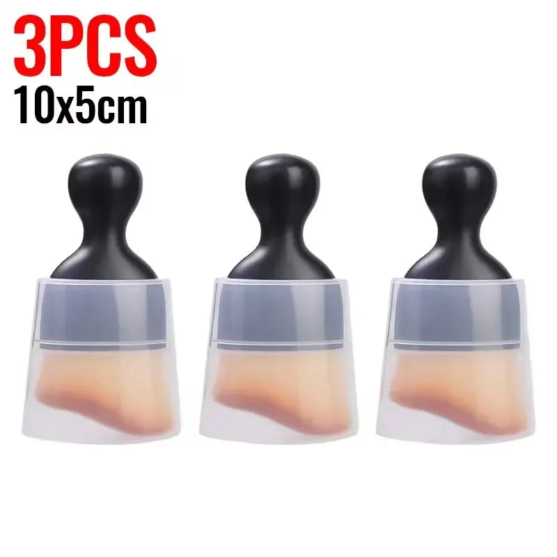 Three black silicone cleaning brushes with clear bases and peach-colored cleaning pads.
