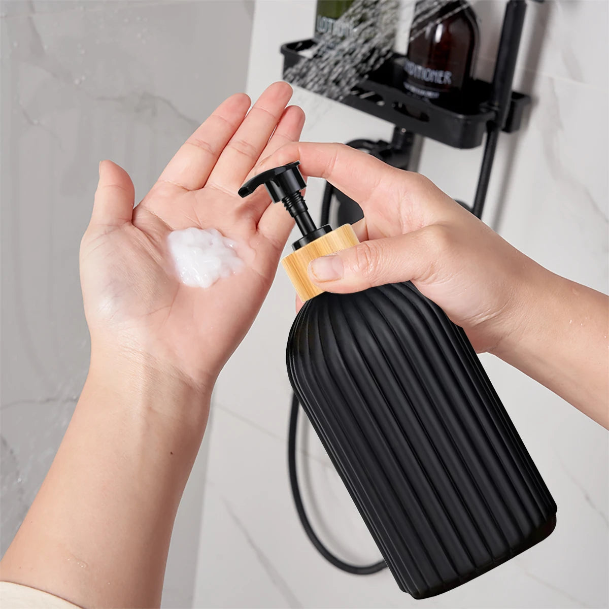 A hand is squeezing a black pump dispenser bottle of soap onto a white sponge on a bathroom counter.