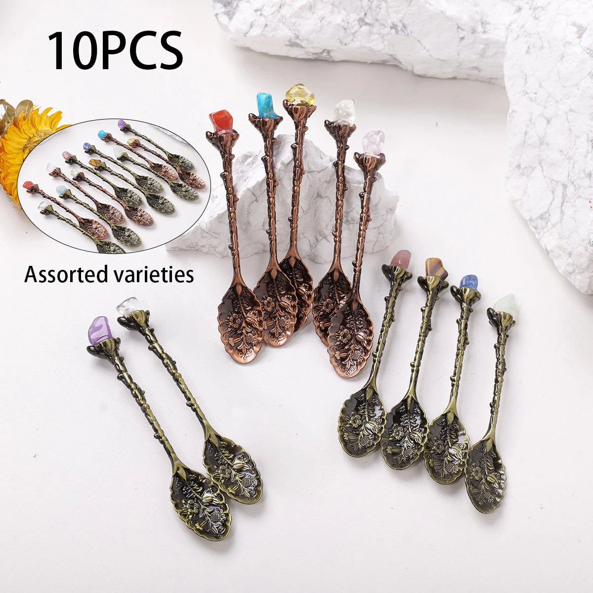 A collection of 10 assorted natural crystal spoons for energy healing displayed on a white background.