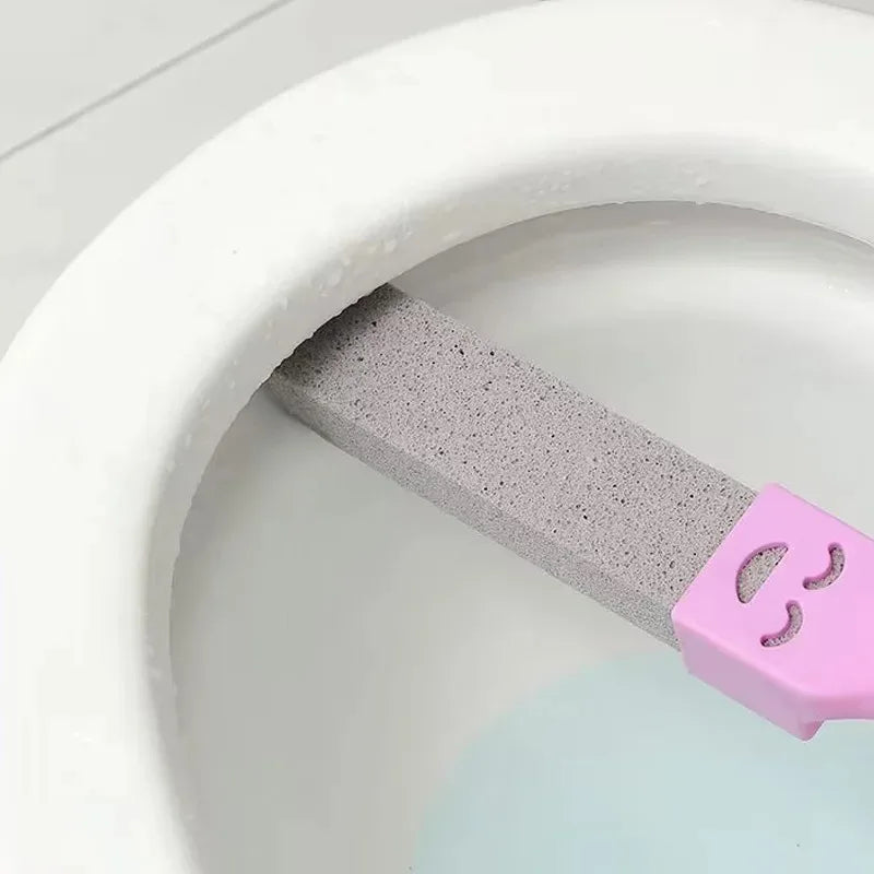 A pink pumice stone stick is placed inside a white toilet bowl.