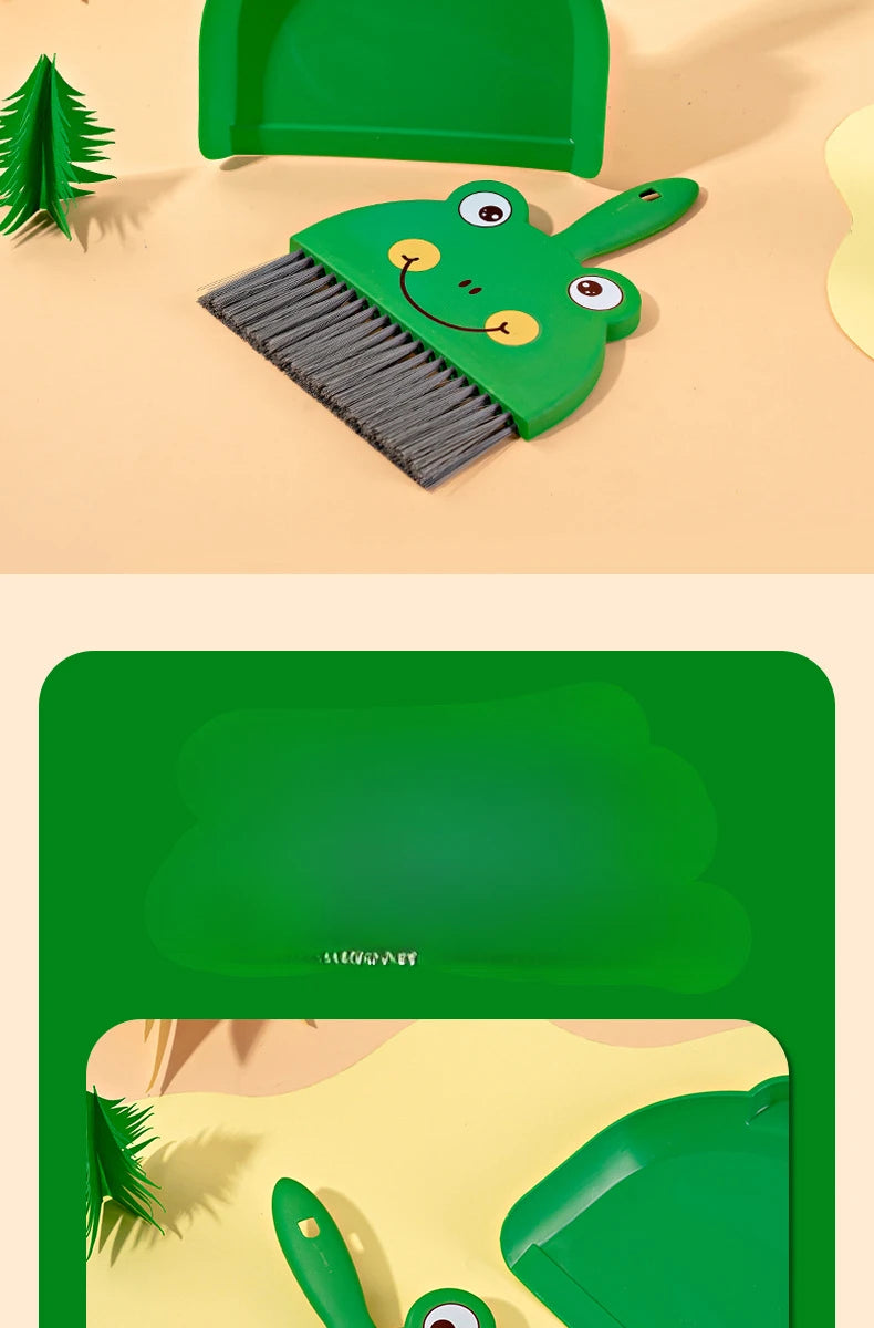 A green cartoon frog broom and dustpan set resting on a light background.