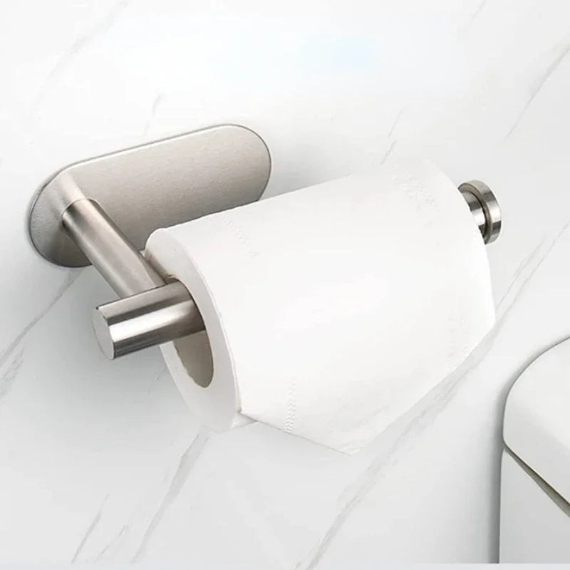 A silver wall mounted toilet paper holder with a white roll is shown against a white marble background.