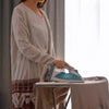 A woman is ironing fabric using a high-temperature resistant wool felt ironing mat.