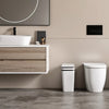 A modern bathroom vanity with a white vessel sink and a white automatic motion sensor trash can next to a potted plant.