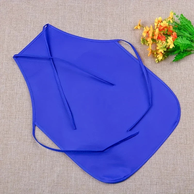 A royal blue non-woven craft apron is displayed on a beige fabric with yellow flowers.