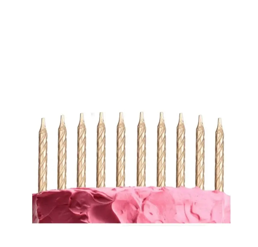 Eine Reihe dekorativer spiralförmiger Geburtstagskerzen steht auf einer rosa Oberfläche.