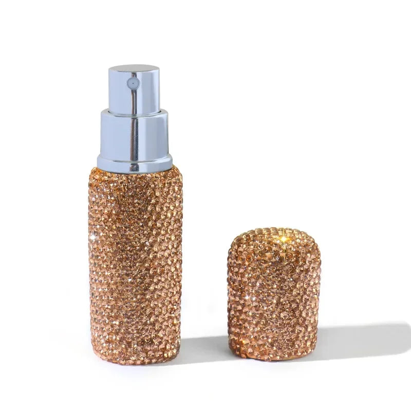 A gold glitter perfume spray bottle with a silver pump dispenser.