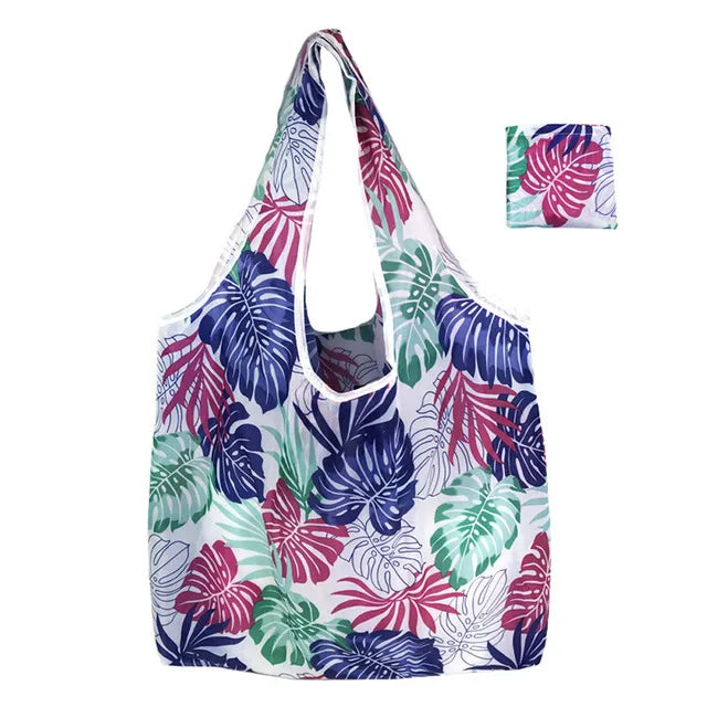 Wiederverwendbare Tasche mit tropischem Blattmuster in Lila, Grün und Weiß.