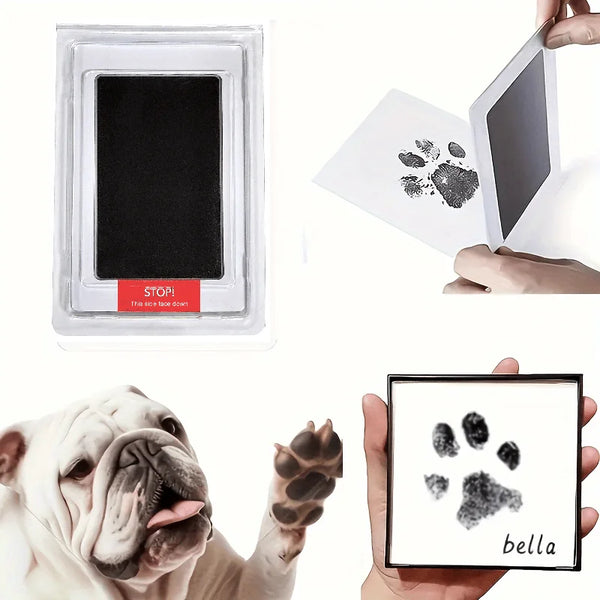 A white dog's paw print is stamped onto a black ink pad, demonstrating the Pet Paw Print Commemorative Ink Pad.