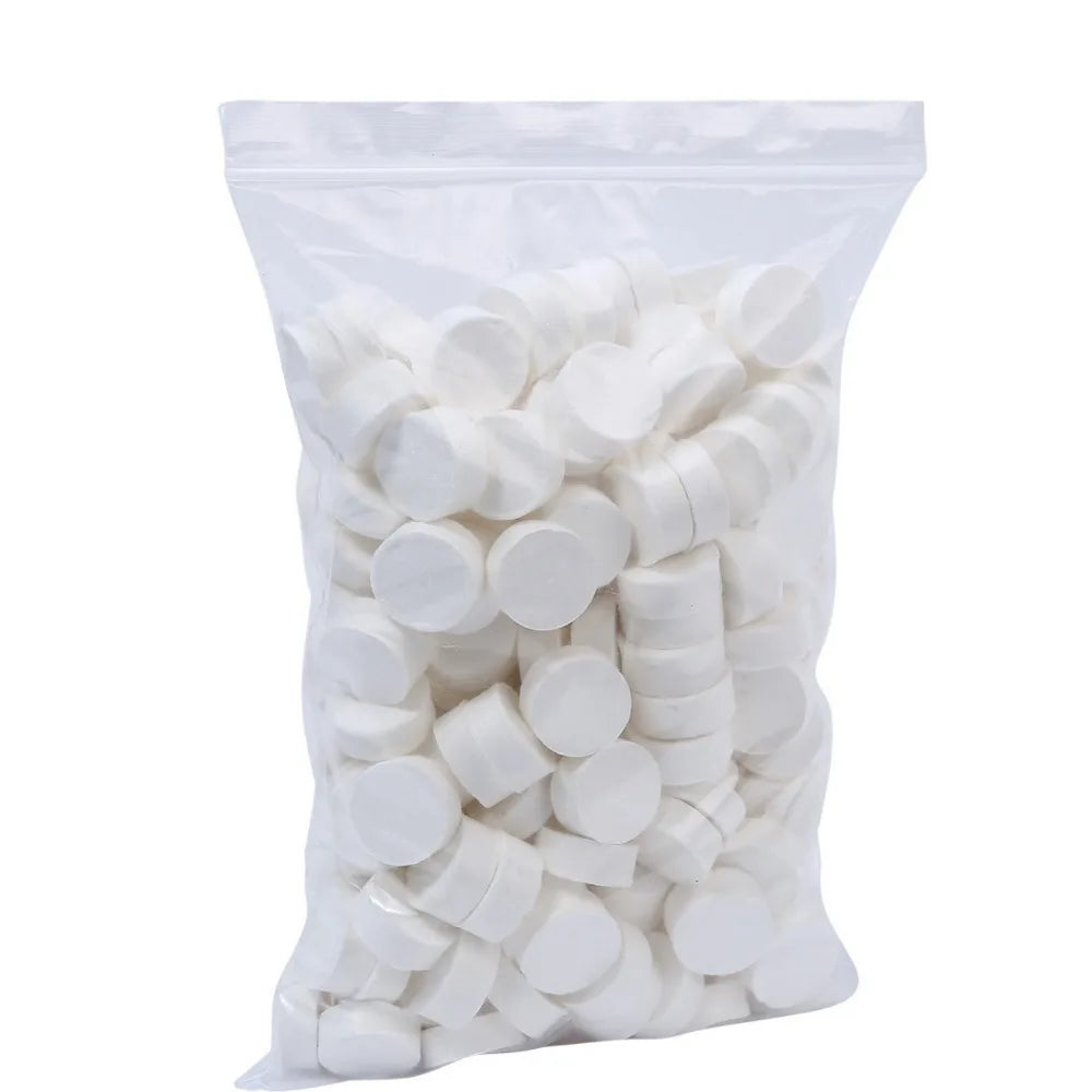 A clear plastic bag filled with white disposable compressed travel towels.