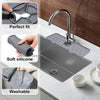 A kitchen faucet with a silicone drainer and splash guard mat installed on a sink.