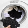 A hand is holding a black little bear sticky cotton product inside a white container.