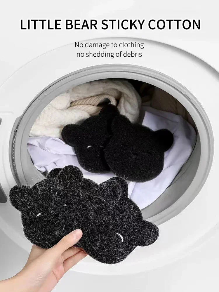 A hand is holding a black little bear sticky cotton product inside a white container.