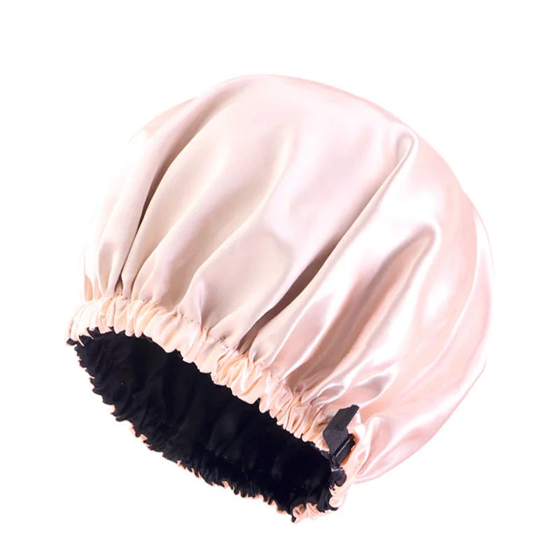 A light pink satin sleep cap with a black faux fur trim.