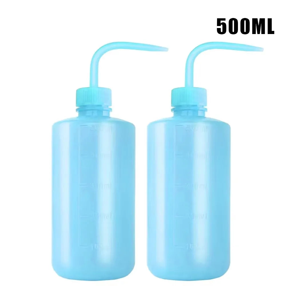A pair of 500ml blue squeeze bottles with measurement marks for tattoo solutions.