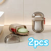Deux contenants en verre transparent de savon ou de lotion blanche avec des couvercles rouges sont exposés sur une surface cl