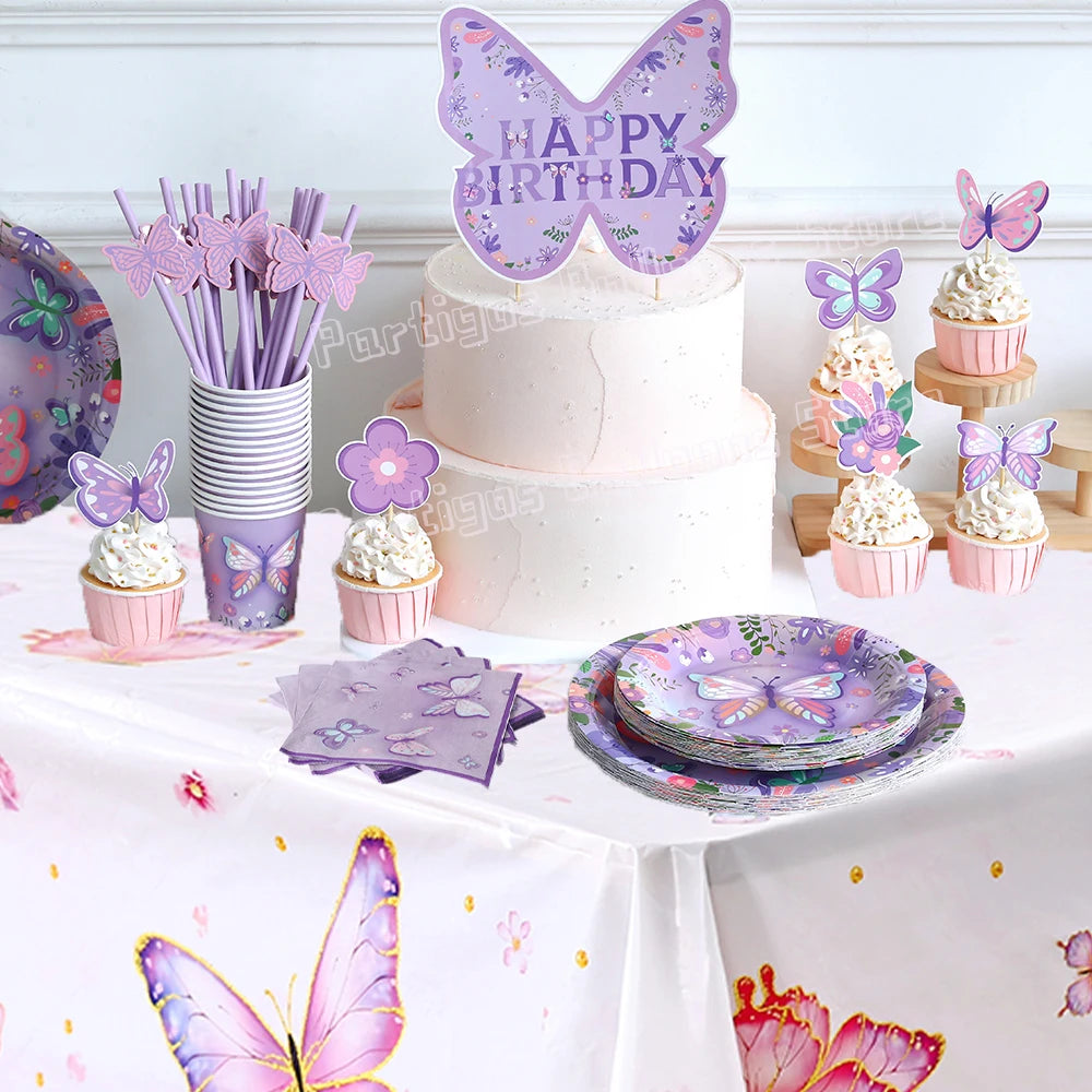 Un gâteau d'anniversaire rose décoré de toppers papillons violets sur une nappe blanche.