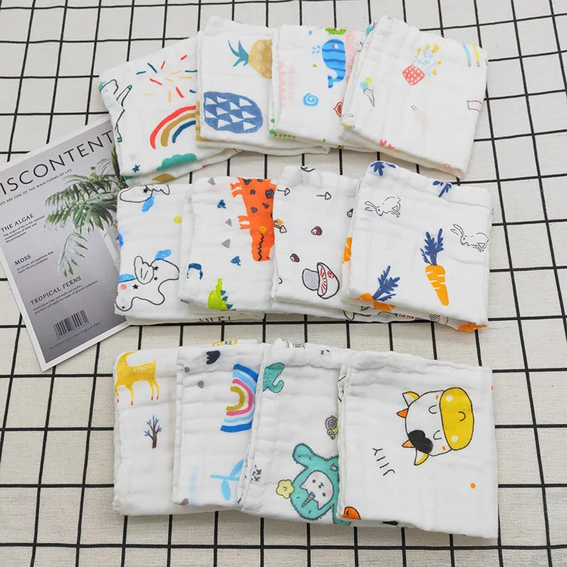 Eine Sammlung weißer Baumwoll-Muslin-Waschlappen mit bunten botanischen und tierischen Drucken.