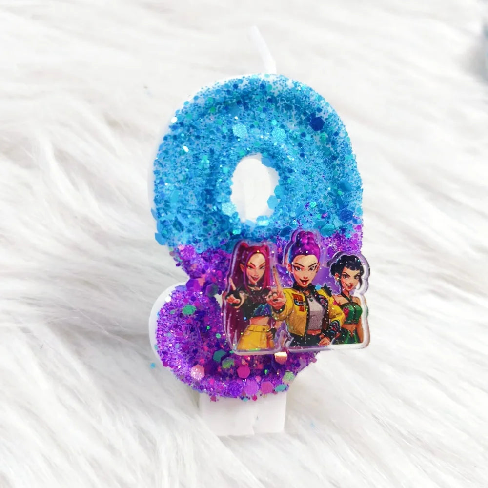 A birthday candle decorated with blue glitter and purple glitter, featuring a character design.