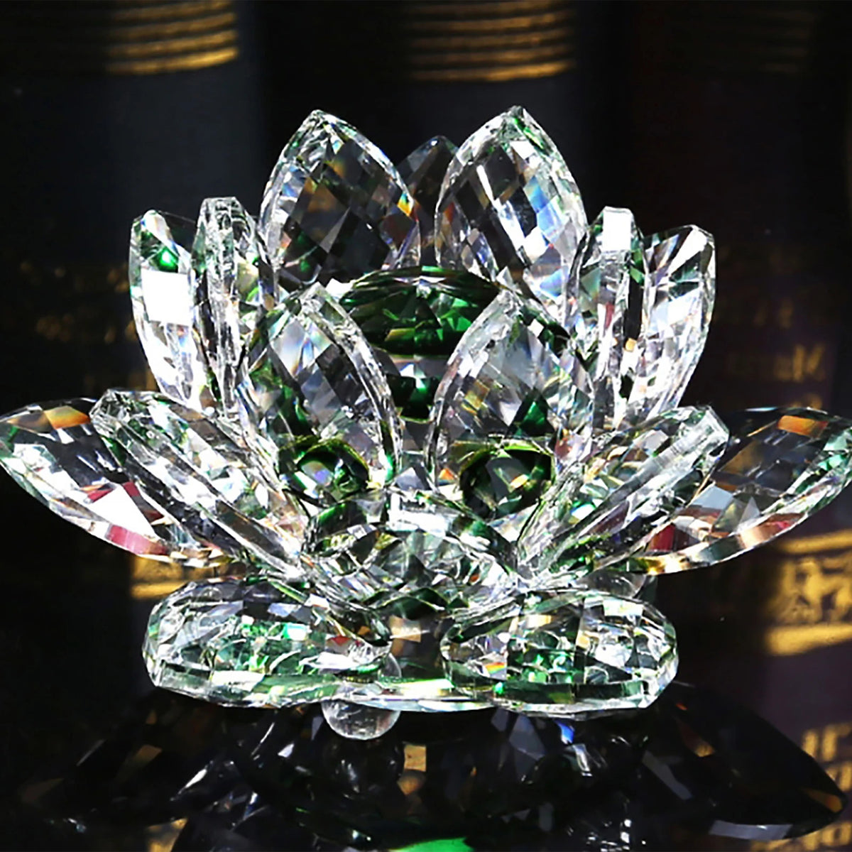 A clear crystal lotus flower tabletop decor with green accents, reflecting light on a dark surface.