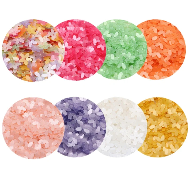 A collection of colorful 10mm flower sequin paillettes in various shades including pink, orange, green, purple, and white.