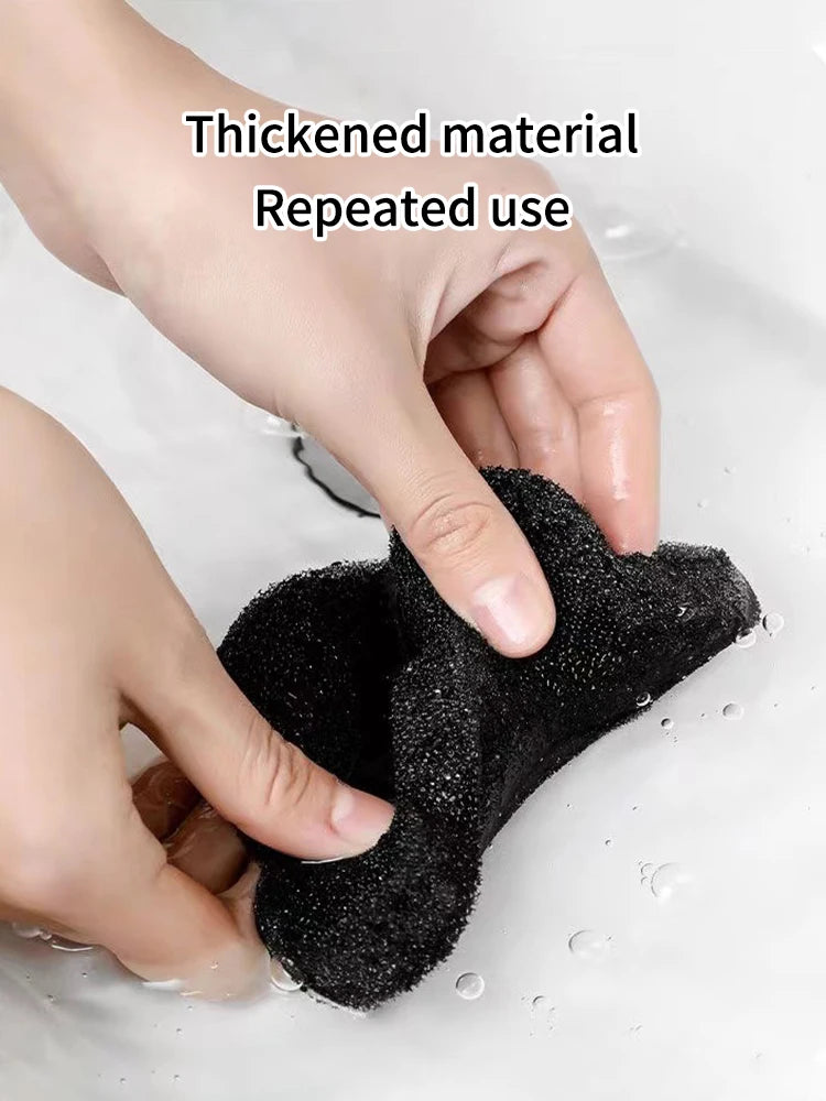 A hand is using a black thickened material sponge to remove water droplets from a surface.