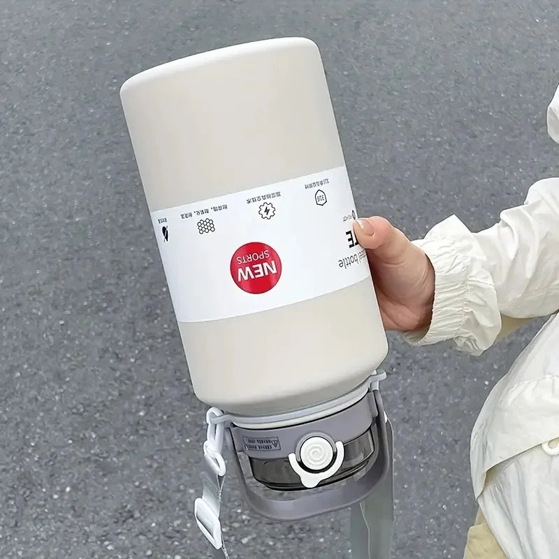 A hand holds a large white stainless steel insulated tumbler with a lid and straw, featuring a NEW Sports label.