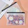A clear plastic zipper storage bag filled with colorful, rolled hair strands and white daisy-shaped silicone accessories.