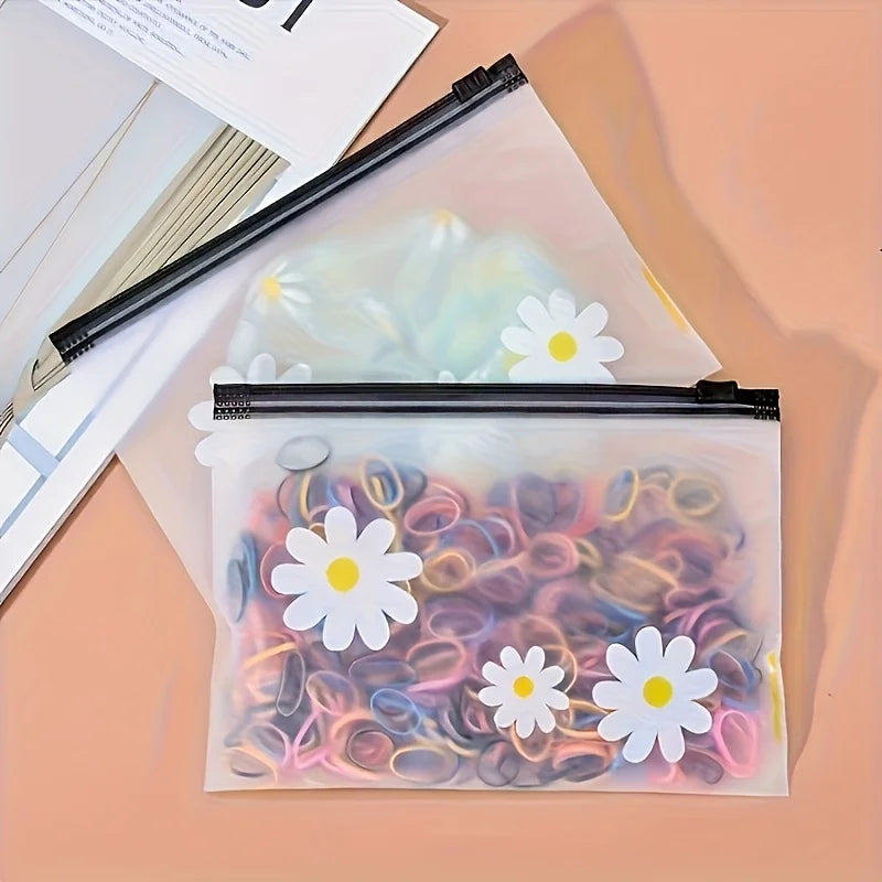 A clear plastic zipper storage bag filled with colorful, rolled hair strands and white daisy-shaped silicone accessories.