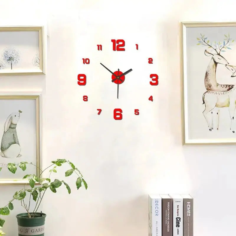 A round red and black analog wall clock with Roman numerals hangs on a white wall next to framed artwork.