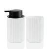 White ceramic foaming soap dispenser with a black pump and a toothbrush holder.