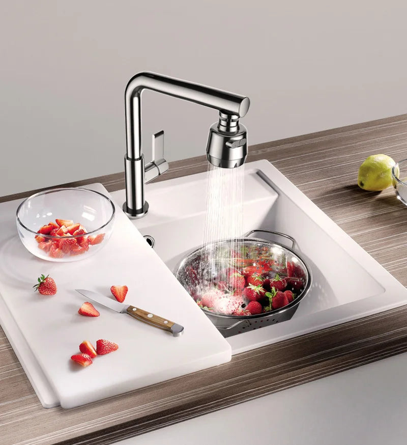 Un extensor de grifo de cocina dispensando agua sobre un tazón de fresas frescas en una instalación de fregadero moderna.