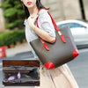 A woman holds a gray and red foldable cosmetic organizer pouch with a strap, next to an open brown leather case.