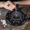 A hand holds a crystal necklace over a wooden divination altar set featuring geometric symbols and crystals.