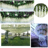 Close-up view of artificial wisteria garlands hanging from a ceiling, showcasing green leaves and white flowers.