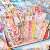A colorful assortment of kawaii DIY sticker packs for crafting and decoration displayed in a pink tray.