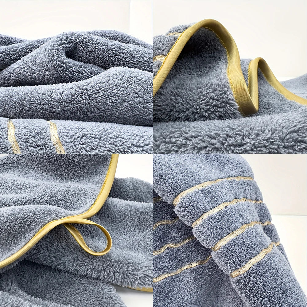 Close-up view of a soft gray microfiber bath towel with gold trim and looped texture.