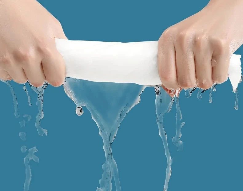Hände halten eine weiße Einweg-Baumwoll-Gesichtstüchchen, aus dem Wasser tropft.
