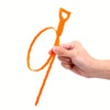 Una mano sostiene un juego de 5 herramientas flexibles para limpiar desagües de color naranja con una punta de alambre curvad