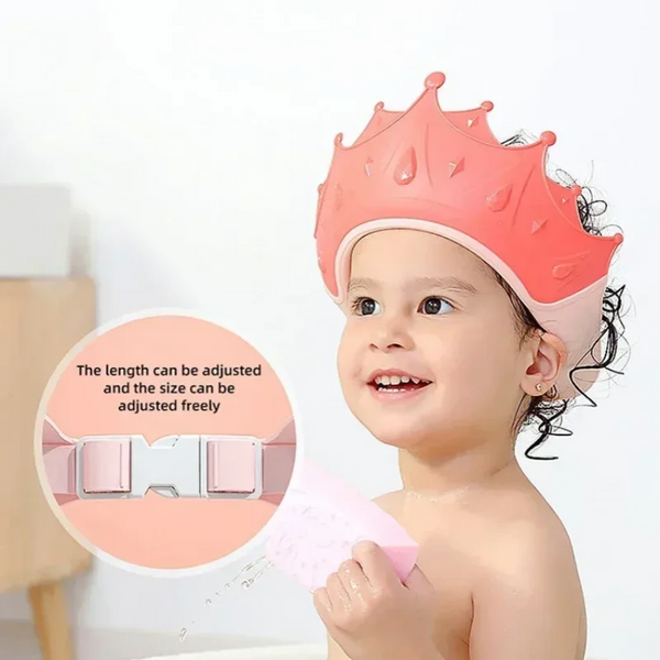 A baby is wearing a pink, adjustable silicone shield cap for bath time.