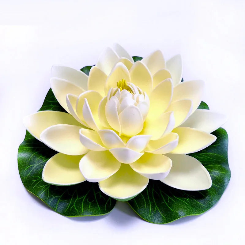 A beautiful artificial yellow and white lotus flower with green leaves.