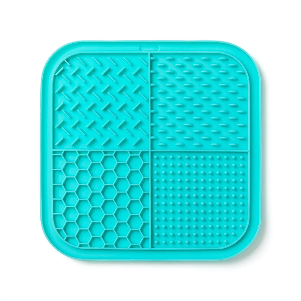 A teal silicone lick mat divided into four sections with different textures for pets.