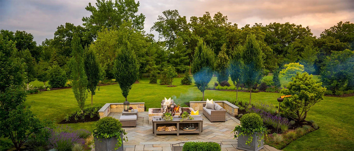 Une housse anti-poussière imperméable pour mobilier de jardin sur une table en bois dans un jardin aménagé.