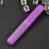 A purple travel and storage toothbrush case lying on a dark surface with small clear objects nearby.