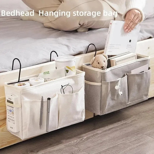 A beige storage rack with hanging bags and compartments for organizing bedside items.