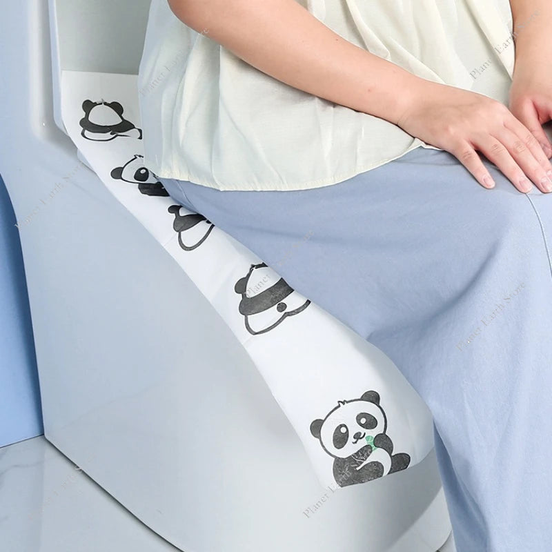 A person is sitting on a light blue seat covered with disposable printing seat covers featuring cute panda designs.