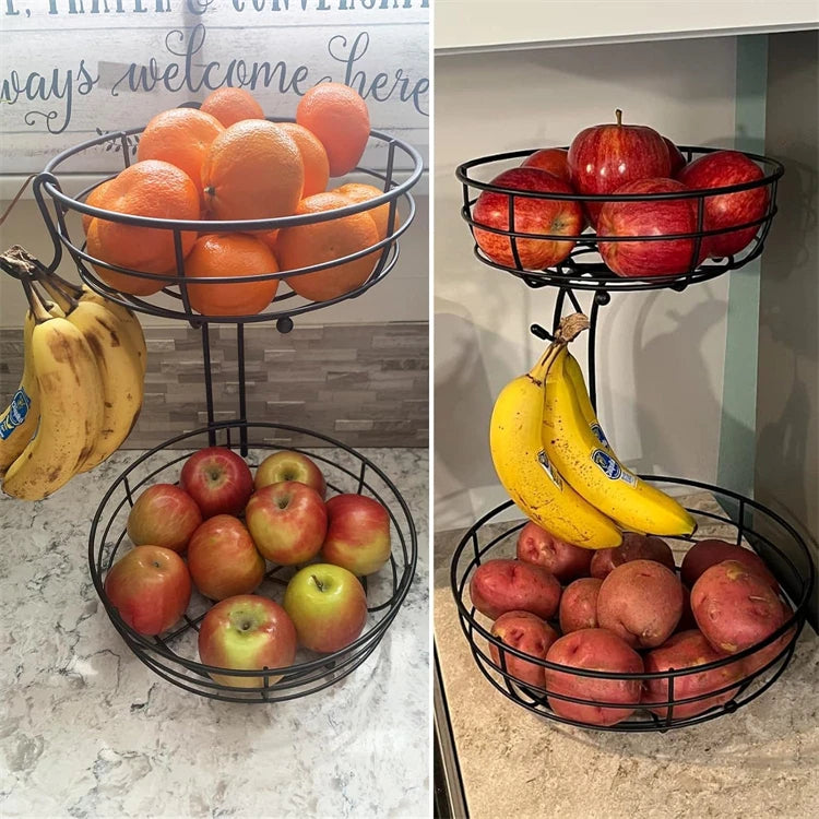 A two-tier metal fruit basket organizer filled with oranges, apples, and bananas on a countertop.