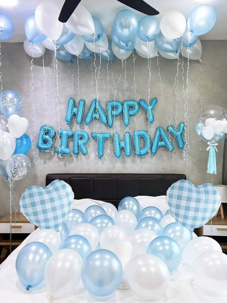 A display of blue and white balloons spelling out Happy Birthday against a gray wall.